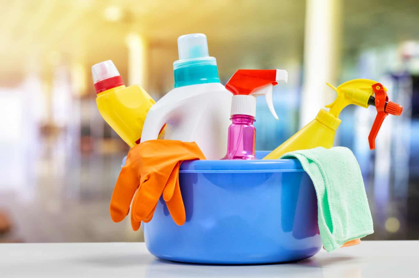 Basket with cleaning items on blurry background