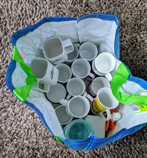 A reusable carrier bag filled with mugs