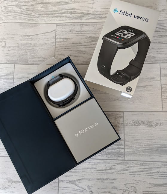 Fitbit Versa in packaging on wooden surface