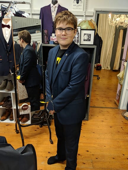 Ben trying on a dark blue suit