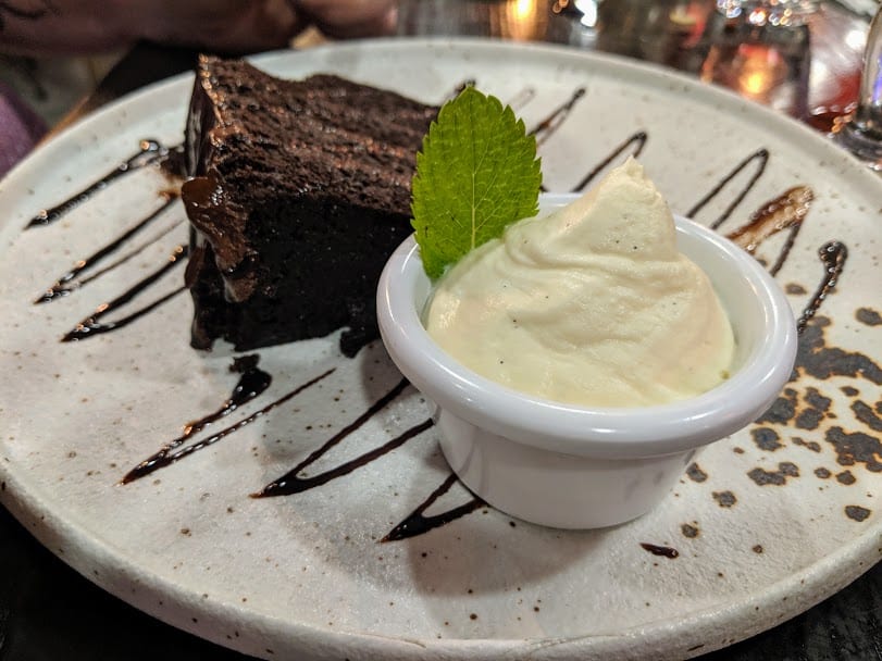 chocolate cake with small ramekin of vanilla icecream.