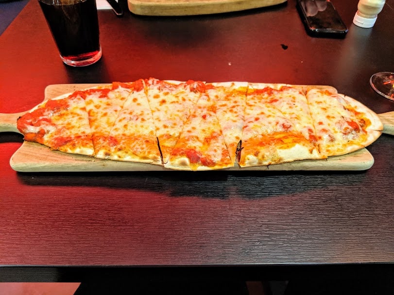 flatbread pizza on wooden board.