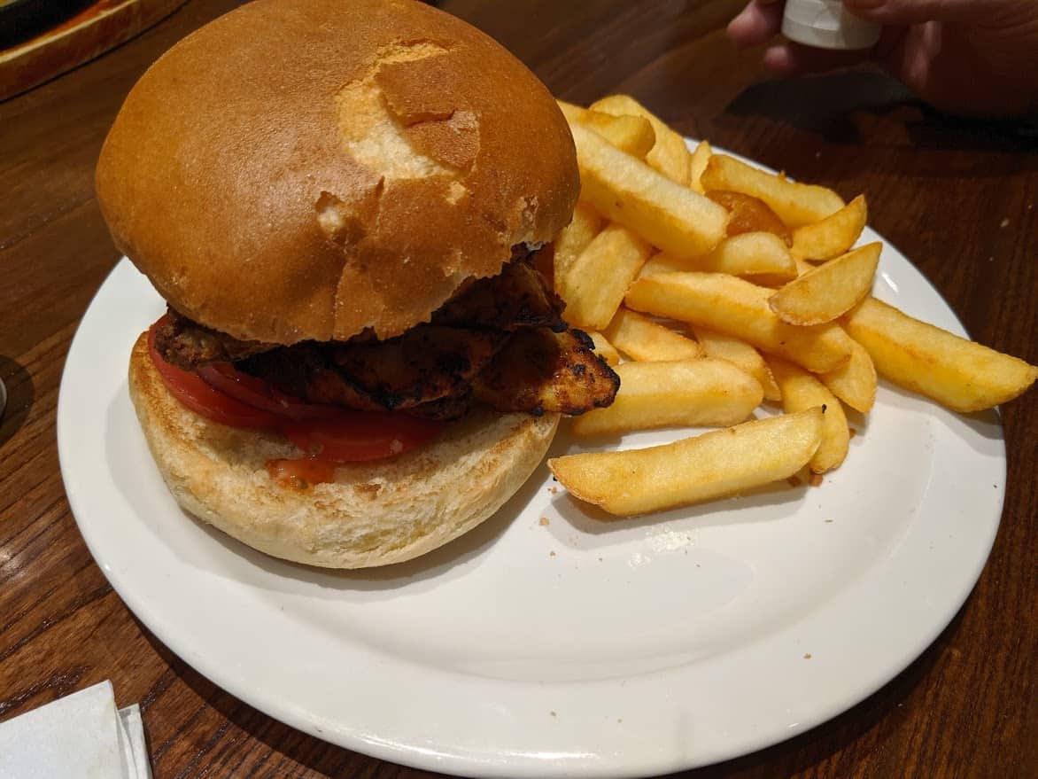 Tandoori burger with chips on a plate.