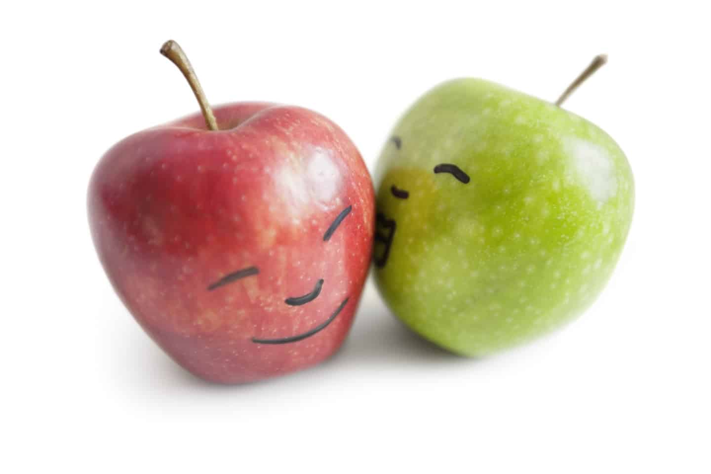 Granny smith apple kissing red apple over white background