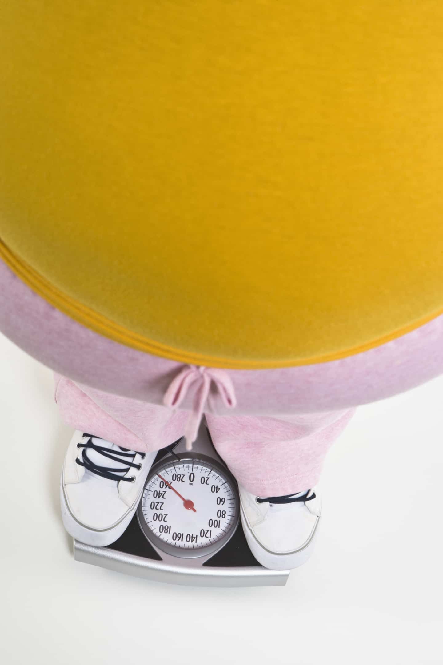 Person standing on bathroom scale, low section