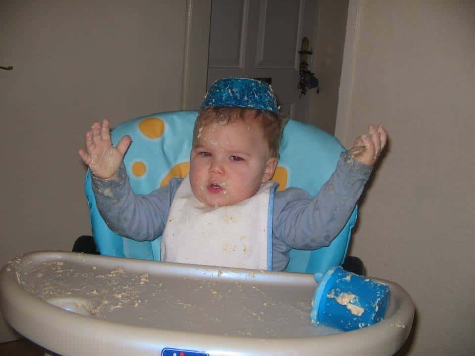 baby covered in food with a bowl on his head