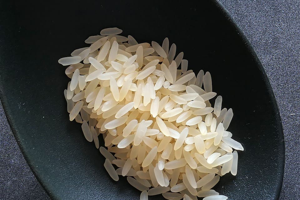 spoon of uncooked rice ready to cook boiled rice perfectly