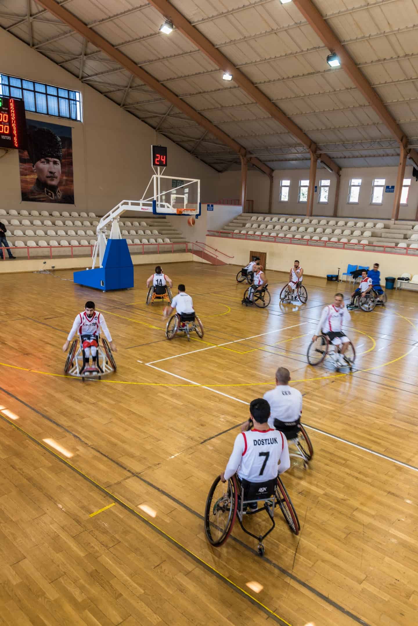 A group of people playing wheelchair basketball in a hall