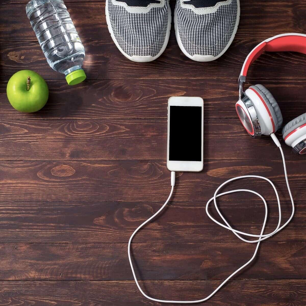 exercise equipment phone trainers water bottle apple and headphones