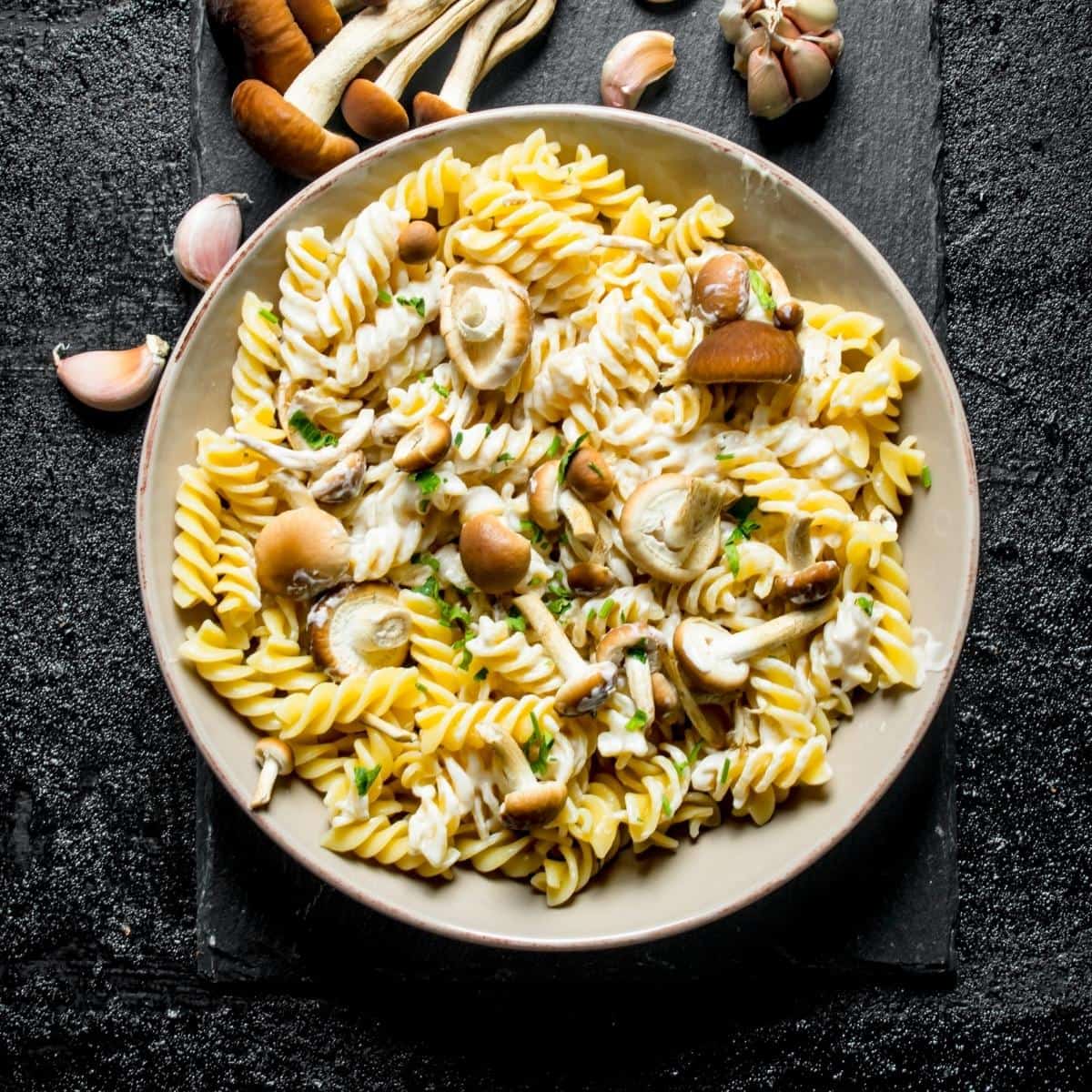 A bowl of food on a plate, with Pasta