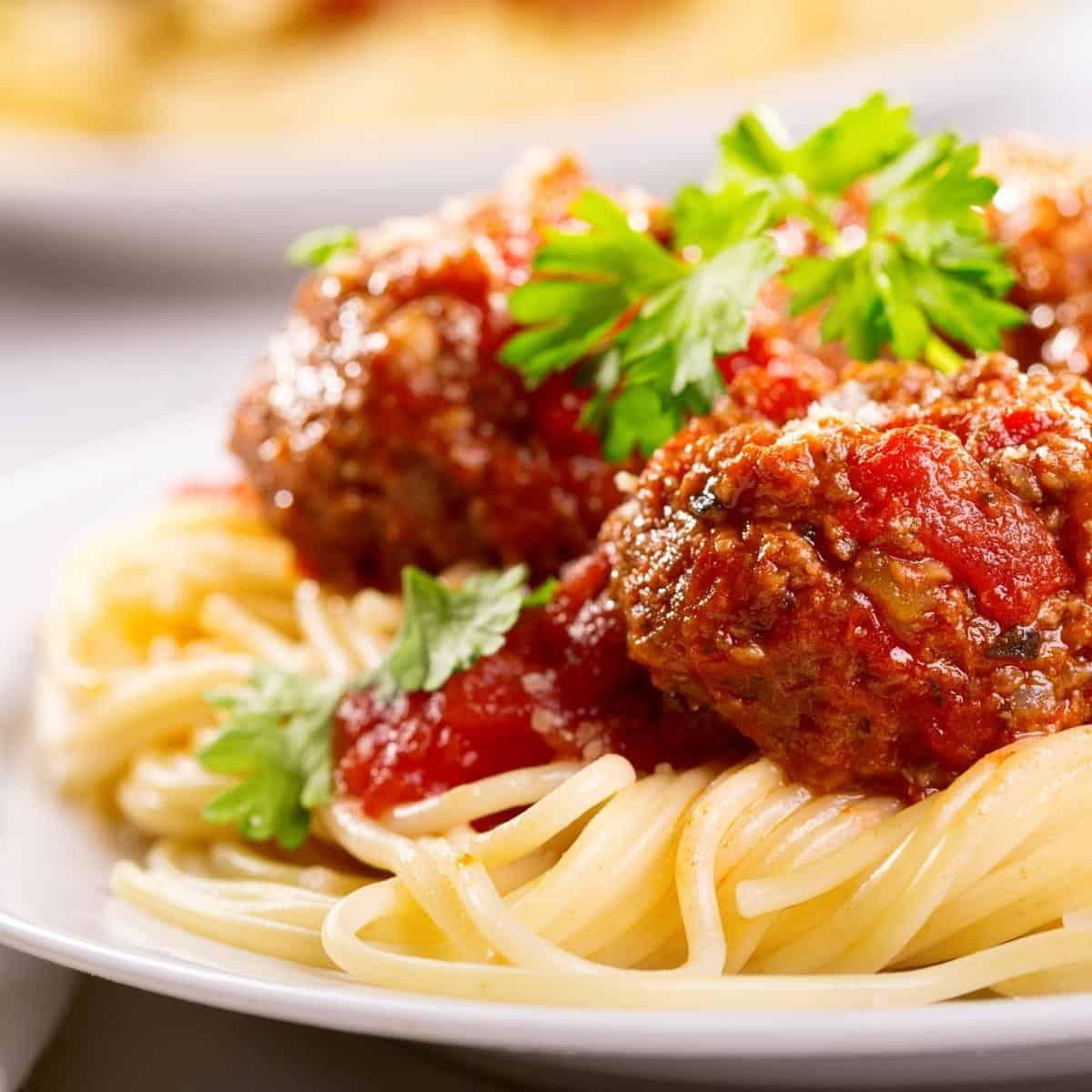 A close up of a plate of food, with Spaghetti and Meatball
