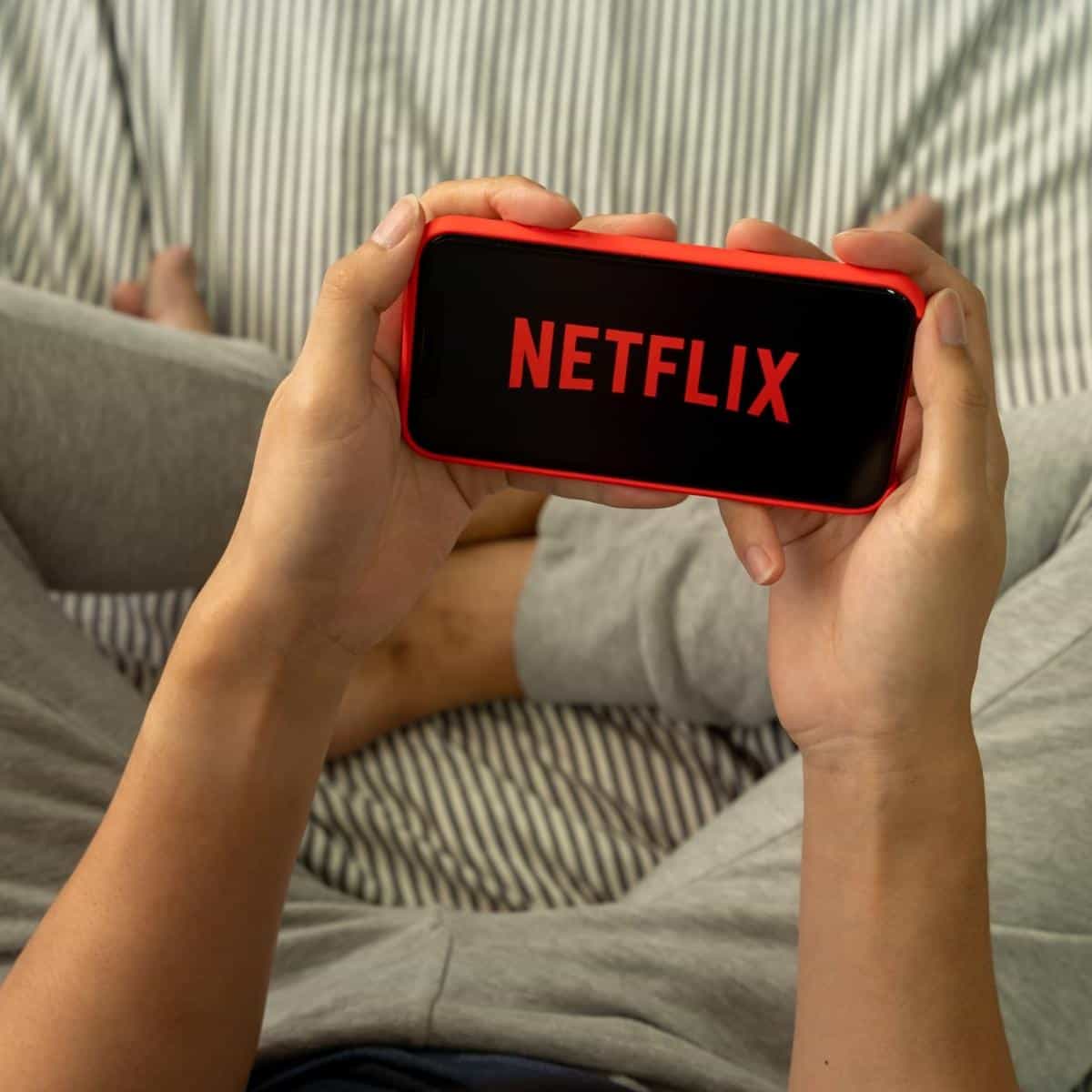Hands holding a smartphone with Netflix viewed via a VPN