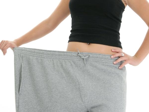 skinny woman wearing large trousers showing weight loss
