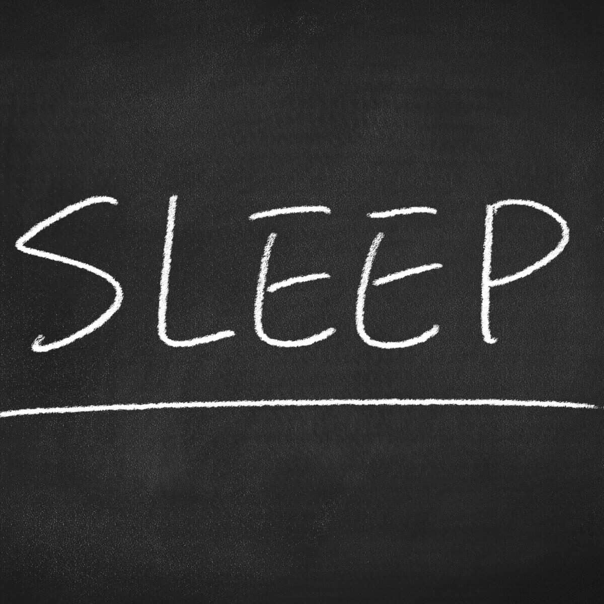 sleep written in chalk on a blackboard in capitals because sleep is stressful, sleep and mental health are linked.