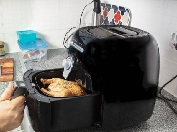 an open air fryer with a chicken inside