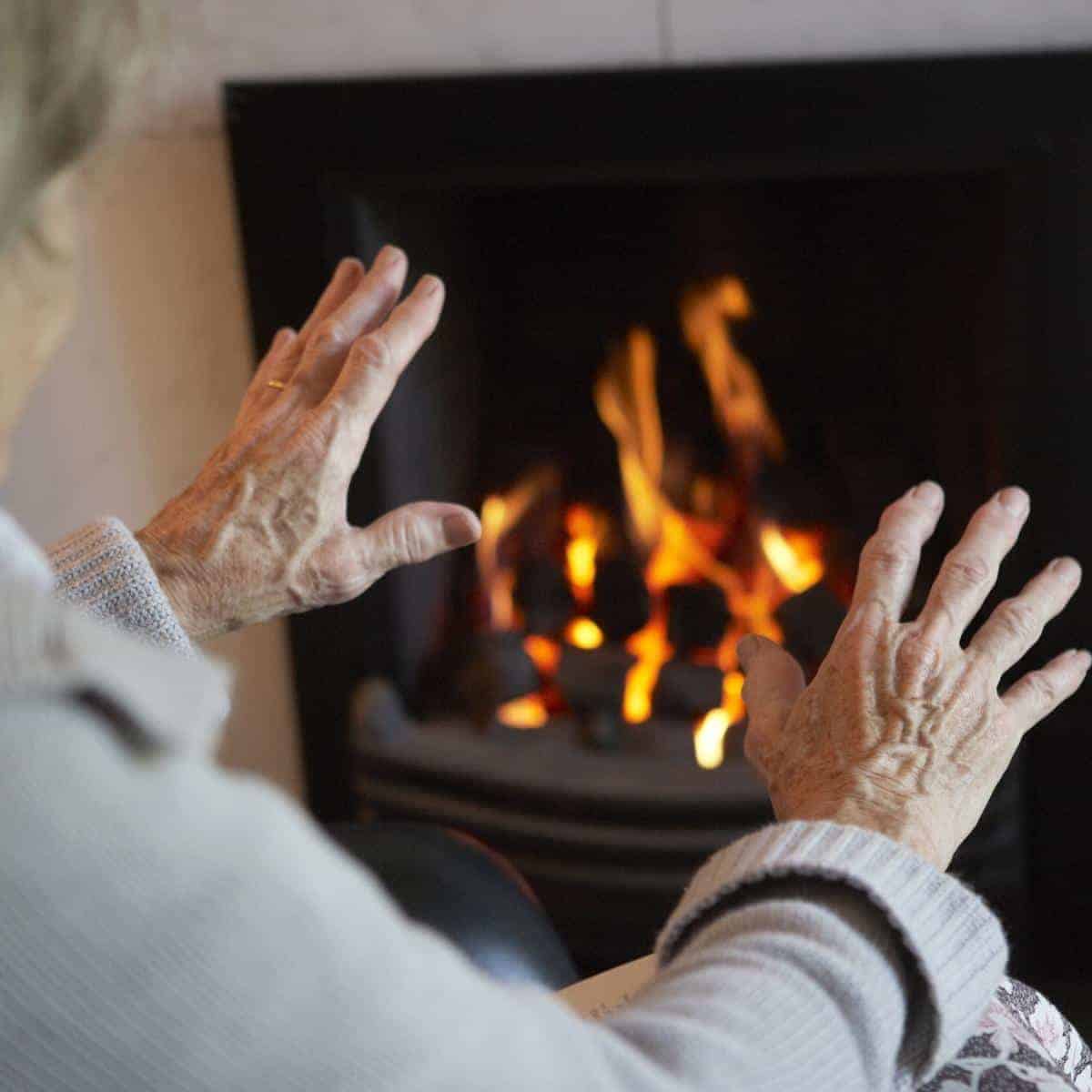 old hands in front of a warm fire