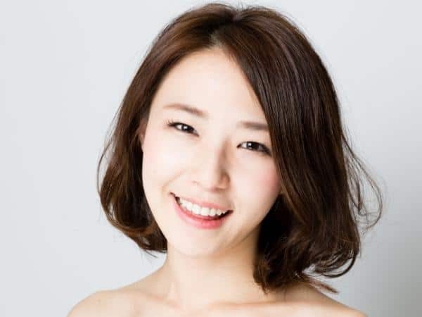 brunette lady with beautiful skin smiling at the camera