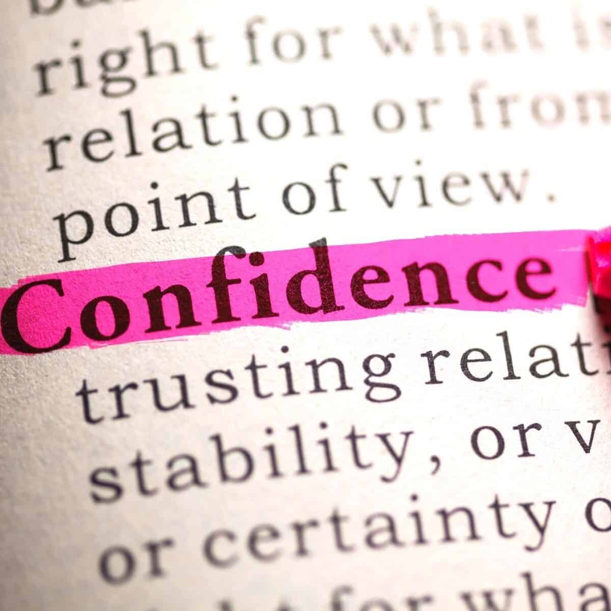 The phrase "confidence" is beautifully highlighted in pink on a page of text, subtly suggesting ways to improve your confidence with every word.