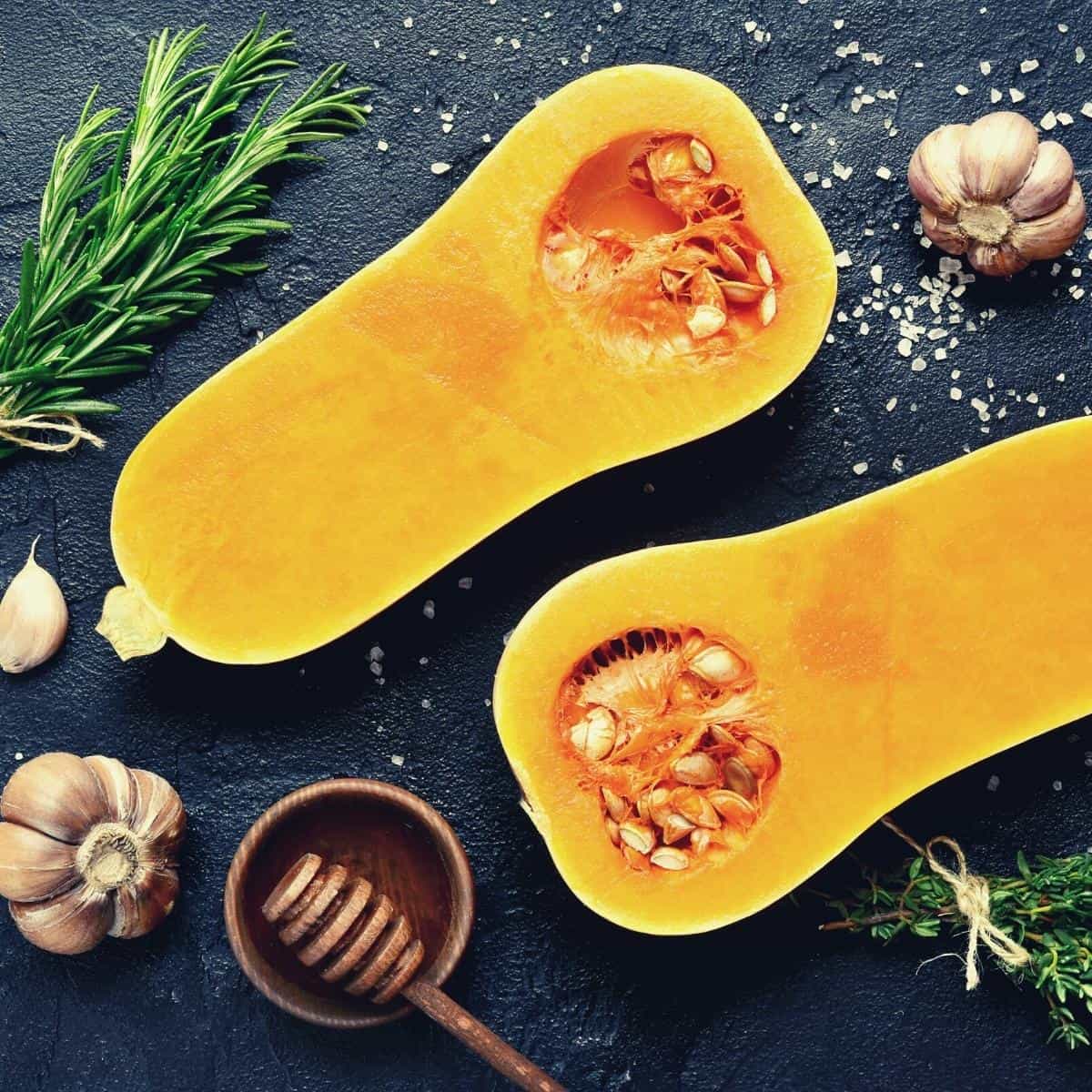 Butternut squash halved on dark work surface