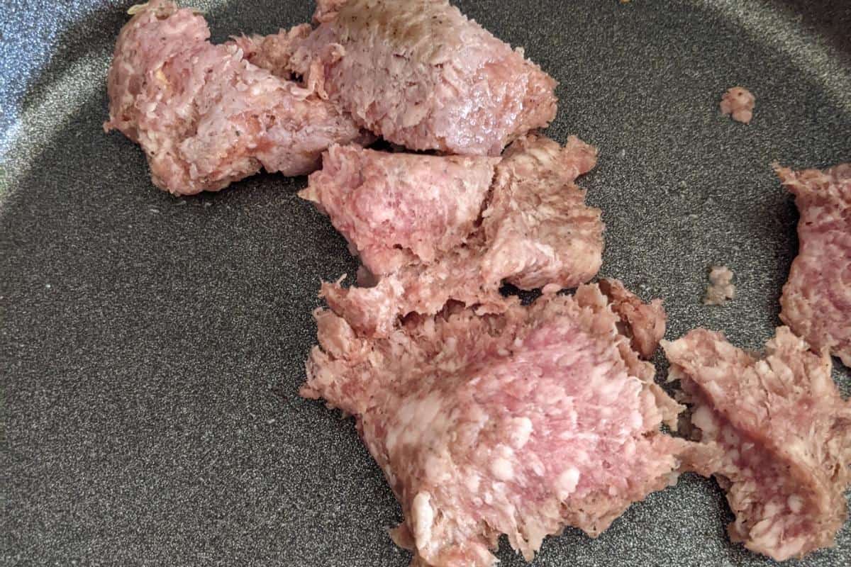 pork mince being broken up in a frying pan