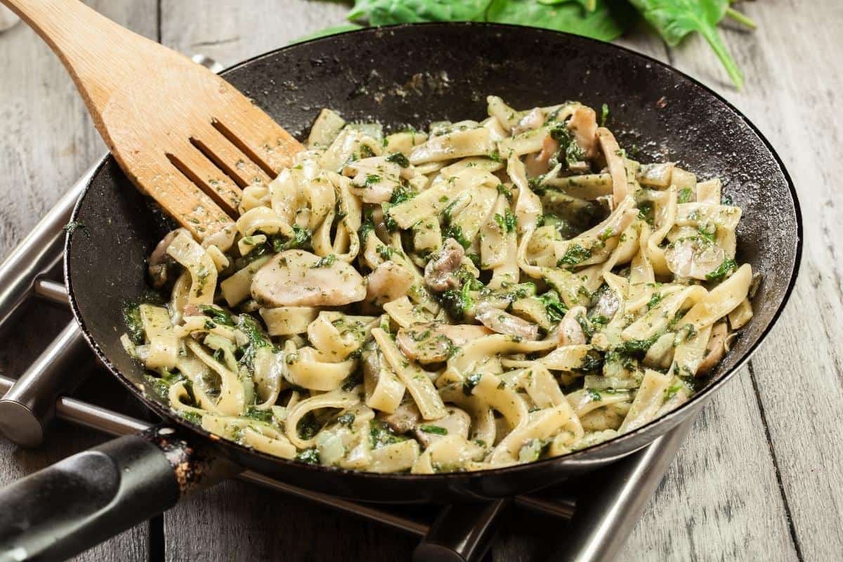 Mushroom and spinach pasta in a frying pan