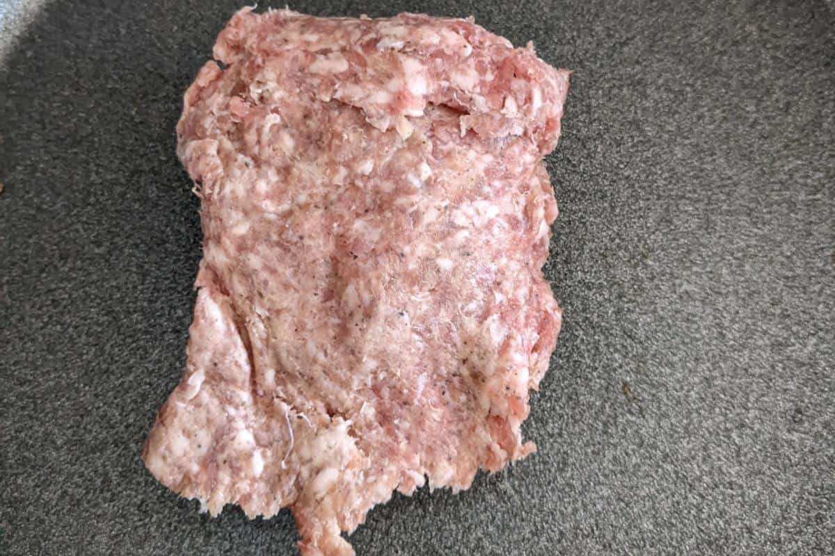 raw pork mince in a grey frying pan