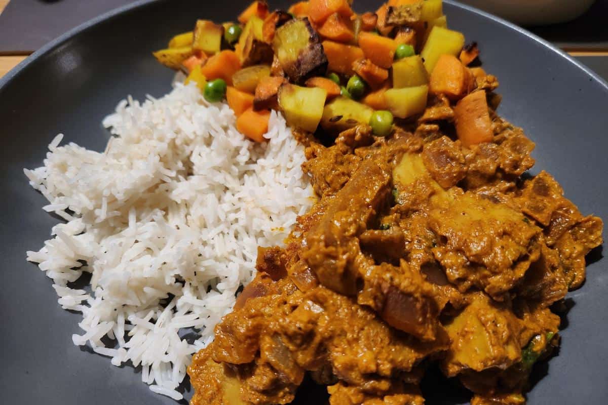 tikka masala, rice and aloo gajar matar in a grey dish