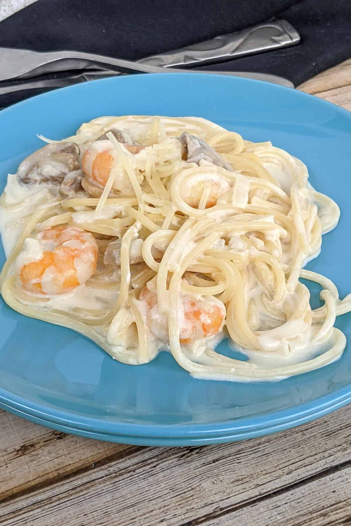 Spaghetti in a white creamy sauce with mushrooms and prawns.