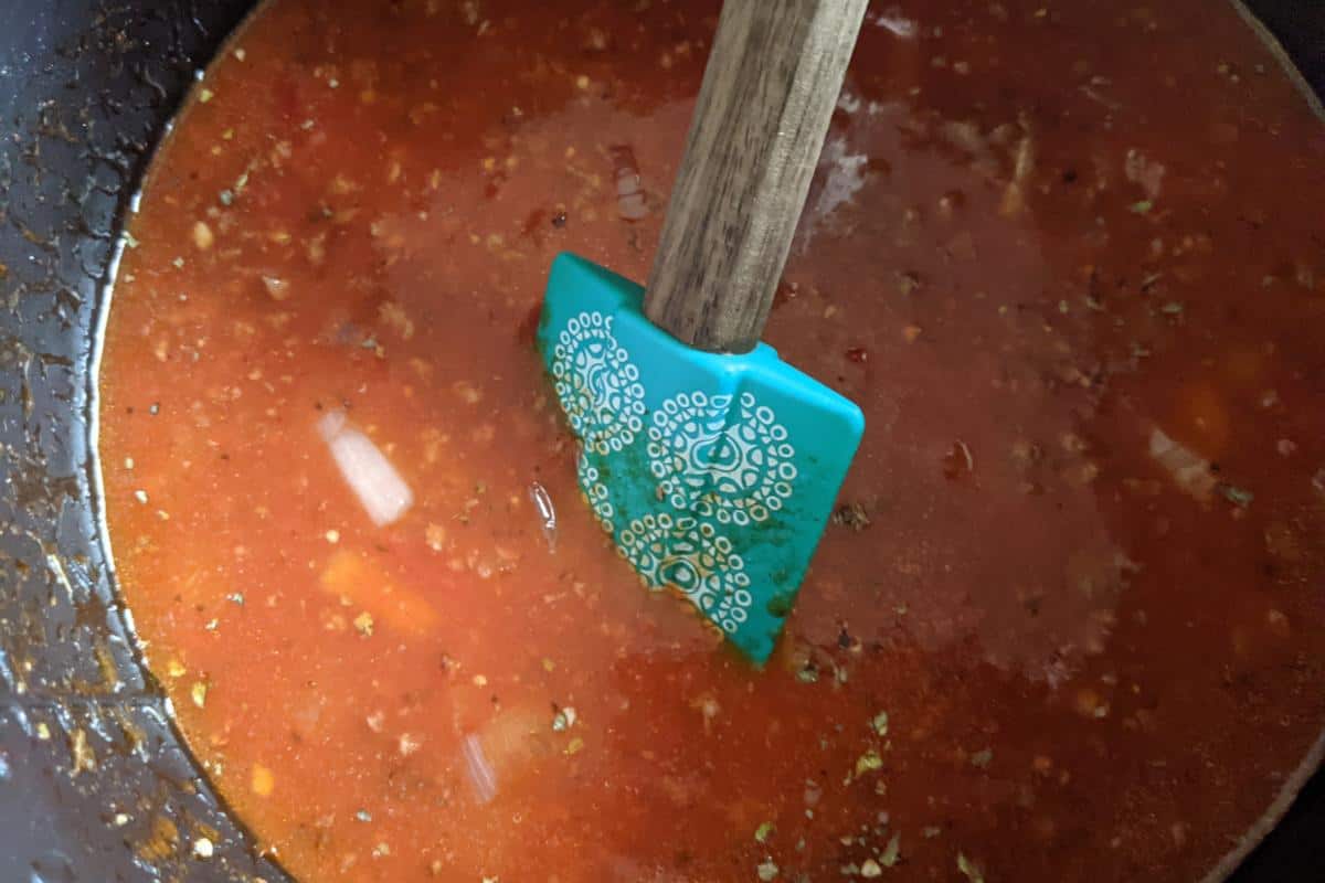 A spatula stirring lasagne soup in an Instant Pot.