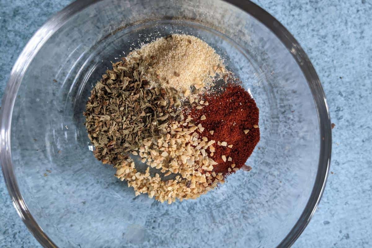 garlic granules, onion granules, herbs and paprika in a glass bowl