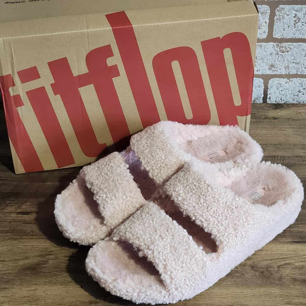 Light pink Fitflop slippers in a slider style with open toes.