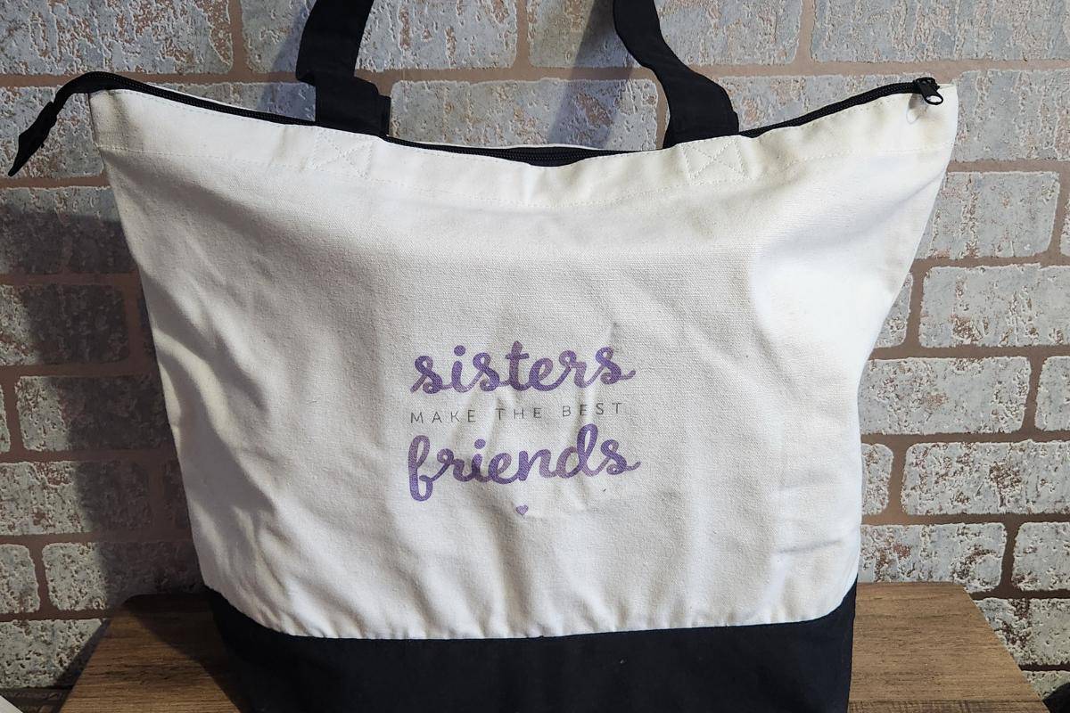 Large zipped bag with the phrase "sisters make the best friends".