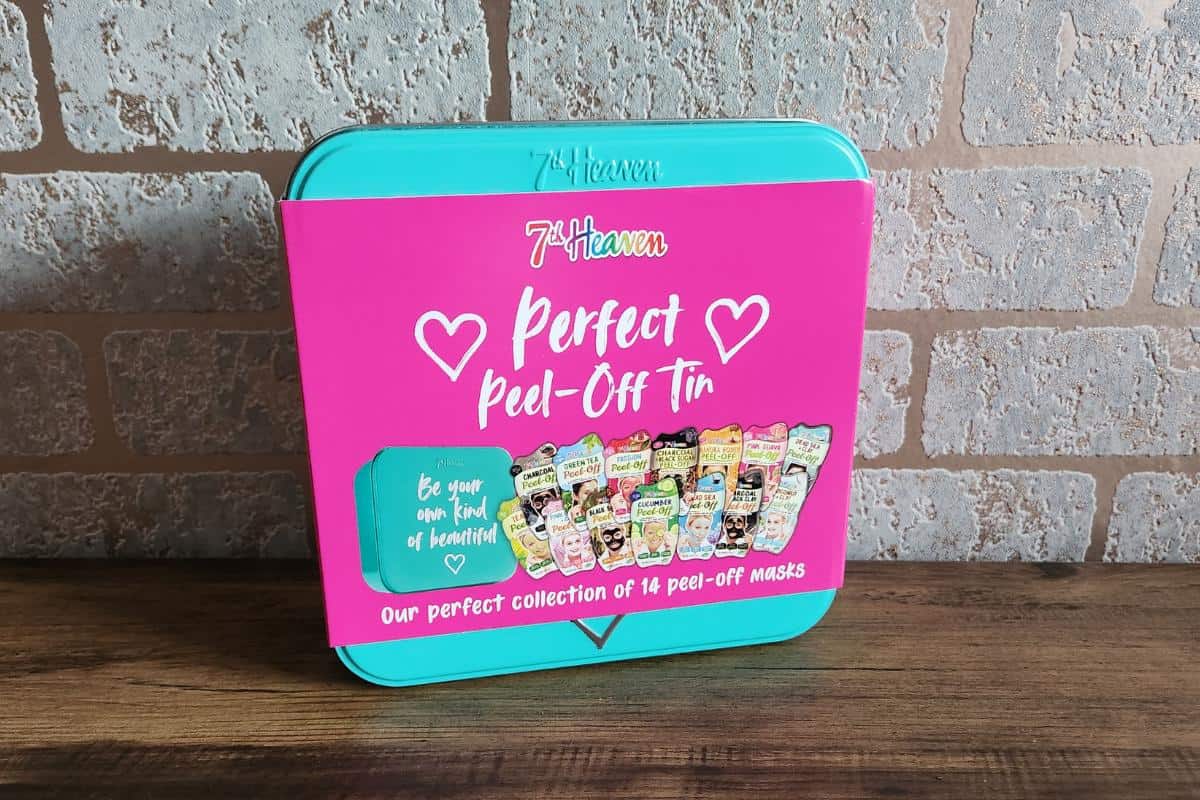 A teal coloured tin containing 7th heaven branded face masks in different varieties.