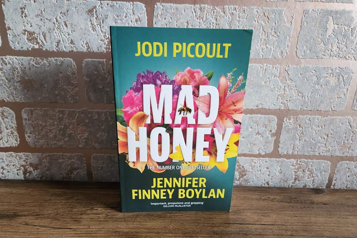 Mad Honey book by Jodi Picoult and Jennifer Finney Boylan, the book has a selection of bright coloured flowers and a bee on the front.