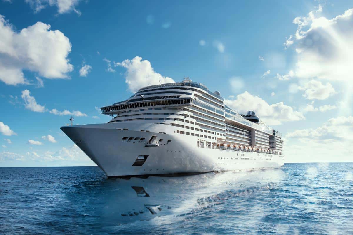 cruise ship on the sea with blue sky and only a few clouds.