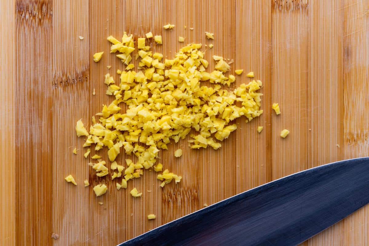 wooden chopping board with minced or finely chopped ginger.