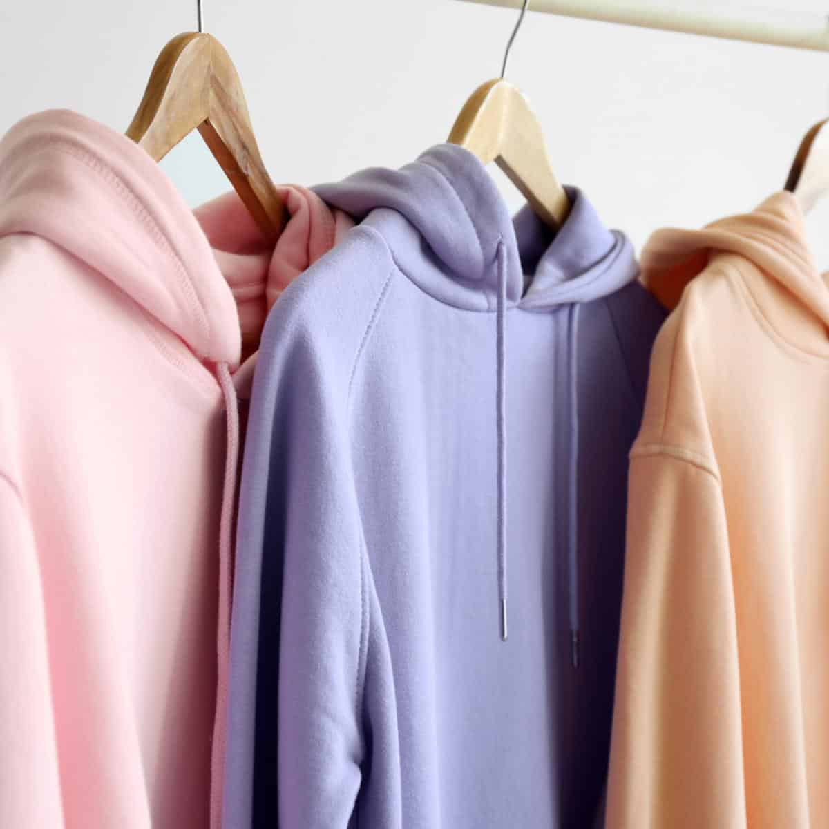 Hoodies hanging on wooden hangers.