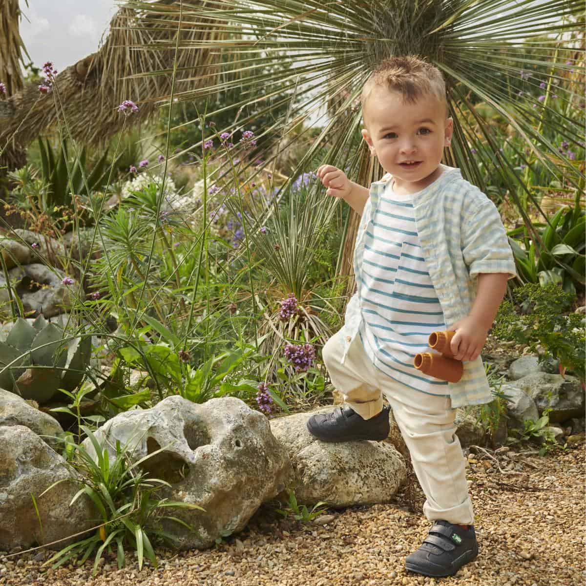 young boy standing outside in the nice weather.