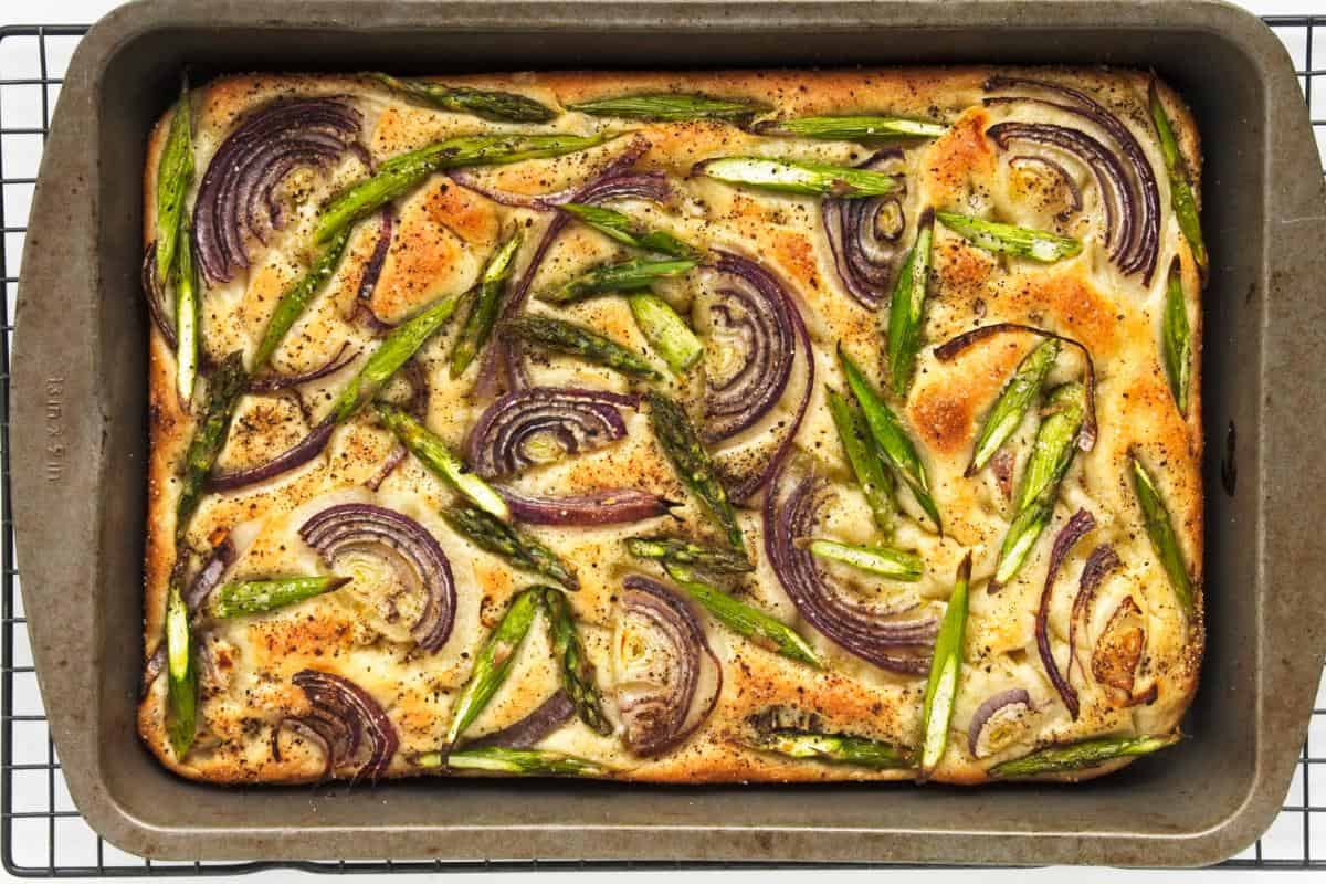 cooked focaccia in tin cooling.