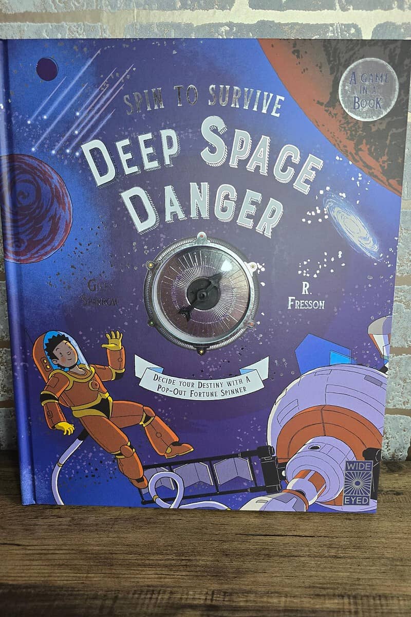 Cover of "Deep Space Danger" by G. Sowden and R. Fresson. This captivating book for children features an astronaut and space elements, with a playful spinner embedded in the center.