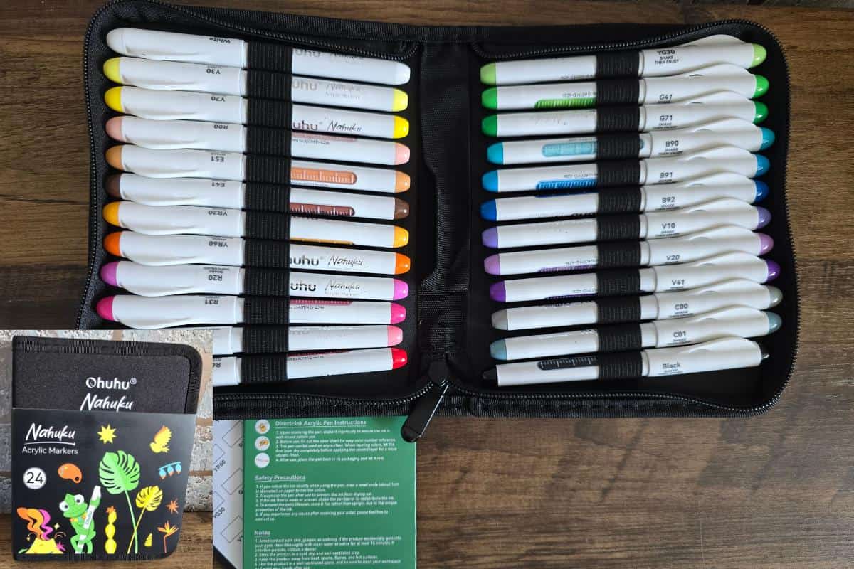A zippered case containing 24 colorful markers is open on a wooden surface, inviting you to spend more time exploring screen-free hobbies. A small instruction booklet and an Ohuhu marker box sit beside it, ready to inspire your next creative project.