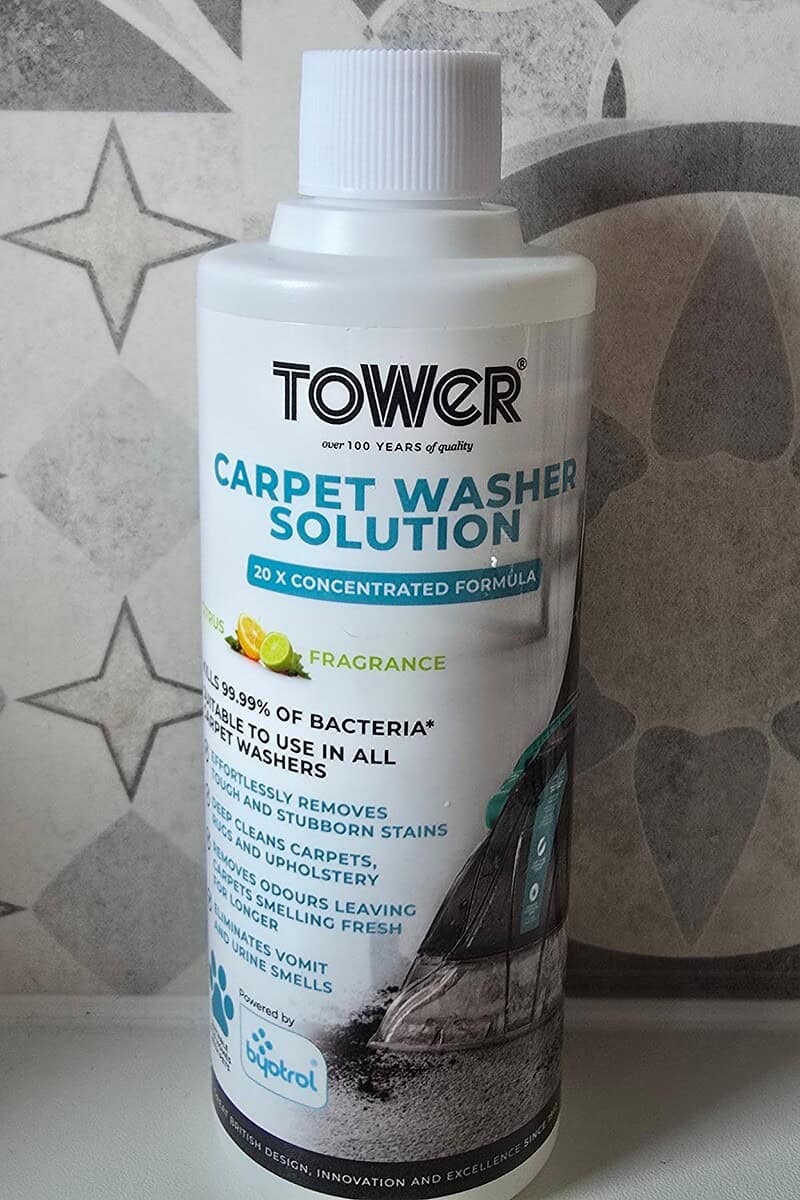 Bottle of Tower Carpet Washer Solution with lemon fragrance, featuring 20x concentrated formula and antibacterial claims against a star-patterned background. Perfect for your TCW5 AquaJetPlus or any carpet washer.