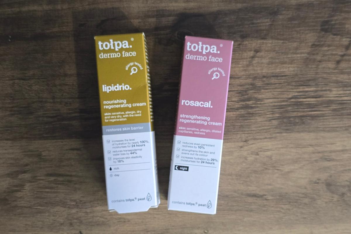 Two boxes of tołpa dermo face creams, perfect as a Stocking Filler or Secret Santa gift, sit on a wooden surface. One is yellow-labeled "lipidrio," the other pink "rosacal"—both nourishing and strengthening regenerating creams.