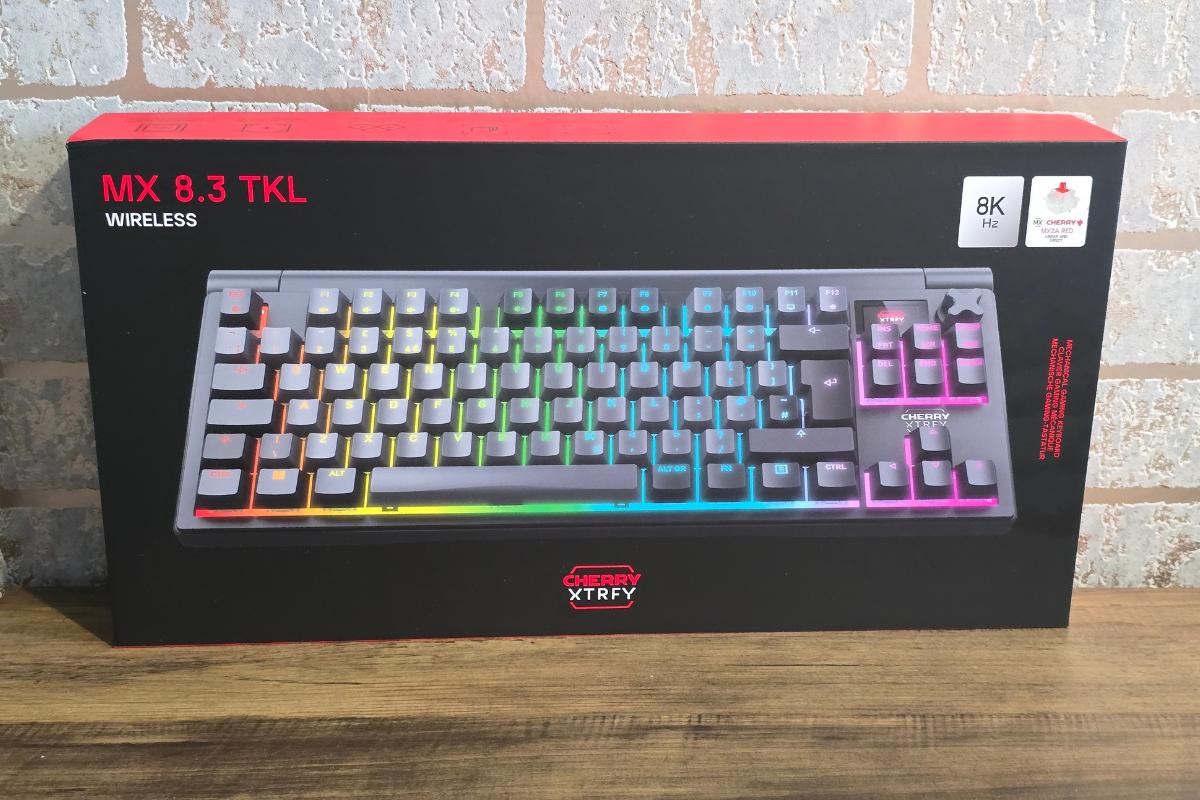 A box for the Xtrfy MX 8.3 TKL wireless keyboard, featuring vibrant RGB lighting and an "8K Hz" highlight on the front—its bold red and black design makes it a standout in any Christmas Gift Guide for Him against a cool brick wall backdrop.