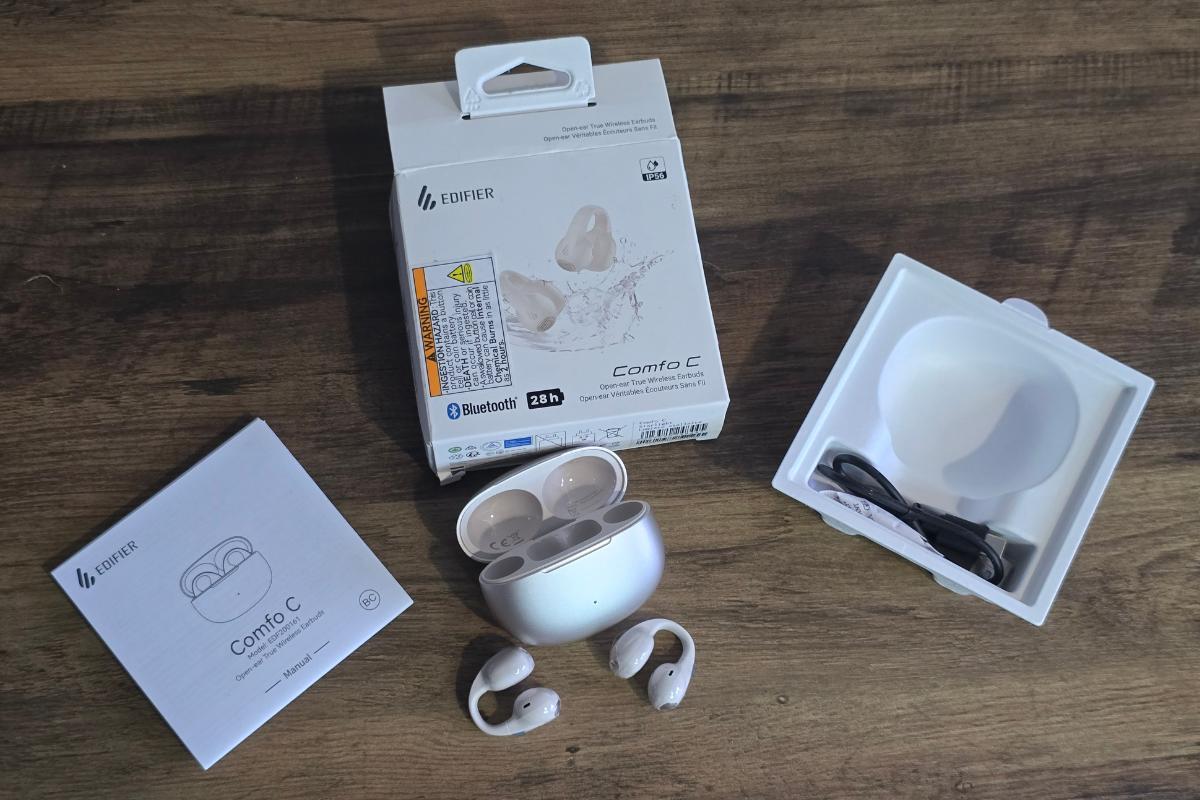 A pair of white Edifier Comfo C wireless earbuds with an open charging case are displayed on a wooden surface alongside their packaging, user manual, and a charging cable—perfect for any Ultimate Christmas Gifts list.