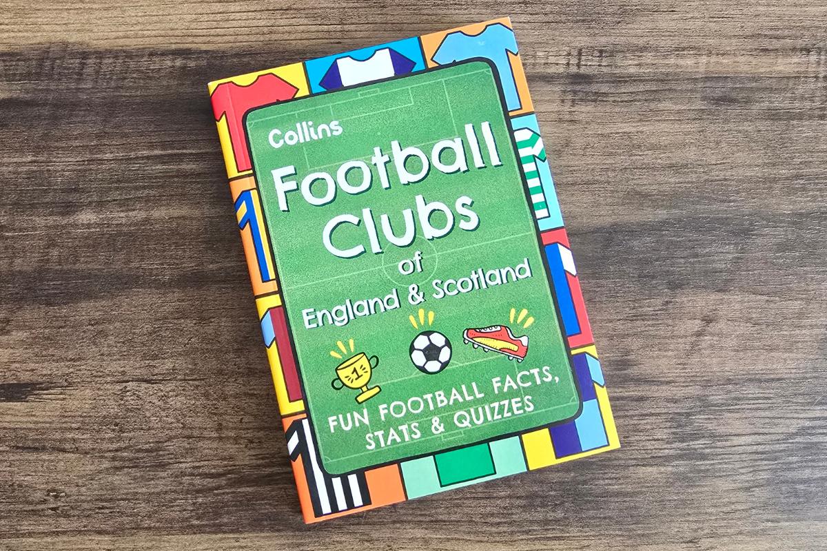 A colorful book titled "Football Clubs of England & Scotland" by Collins lies on a wooden surface—perfect for any children's Christmas gifts, with its cover of football kits, fun facts, stats, and quizzes that make learning about the game exciting.