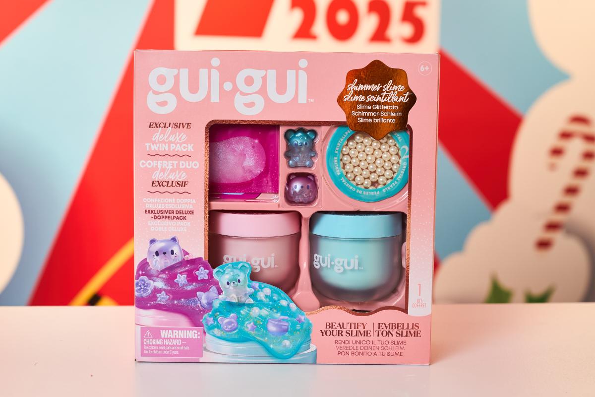 A boxed set of gui-gui deluxe slime kit featuring two pastel-colored containers, sparkly beads, a tiny bear figure, and purple-blue slime. Packaging is pink with playful graphics—perfect for kids toys or Top Toys 2025 Christmas gifts.