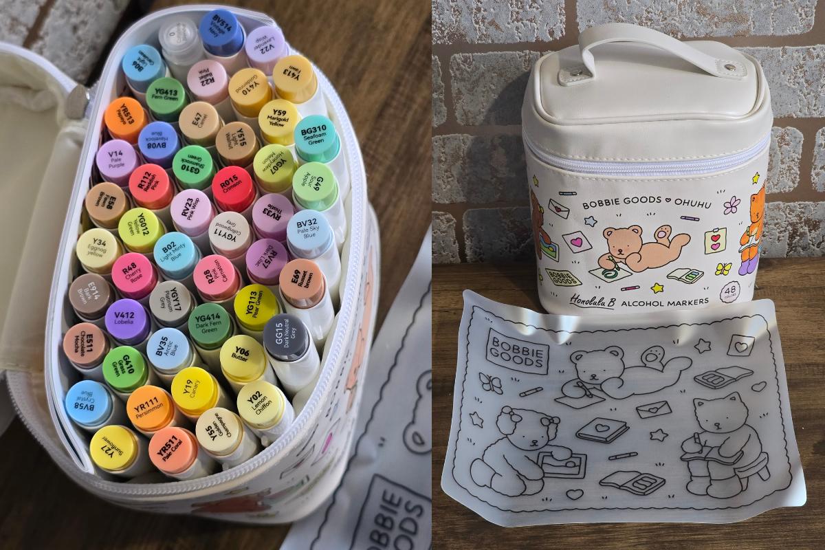 A set of colorful alcohol markers in an open zippered case, next to a matching carrying bag with cartoon bears and art supplies—a charming idea featured in our Christmas Gift Guide. Includes a cloth with the same adorable bear illustrations.