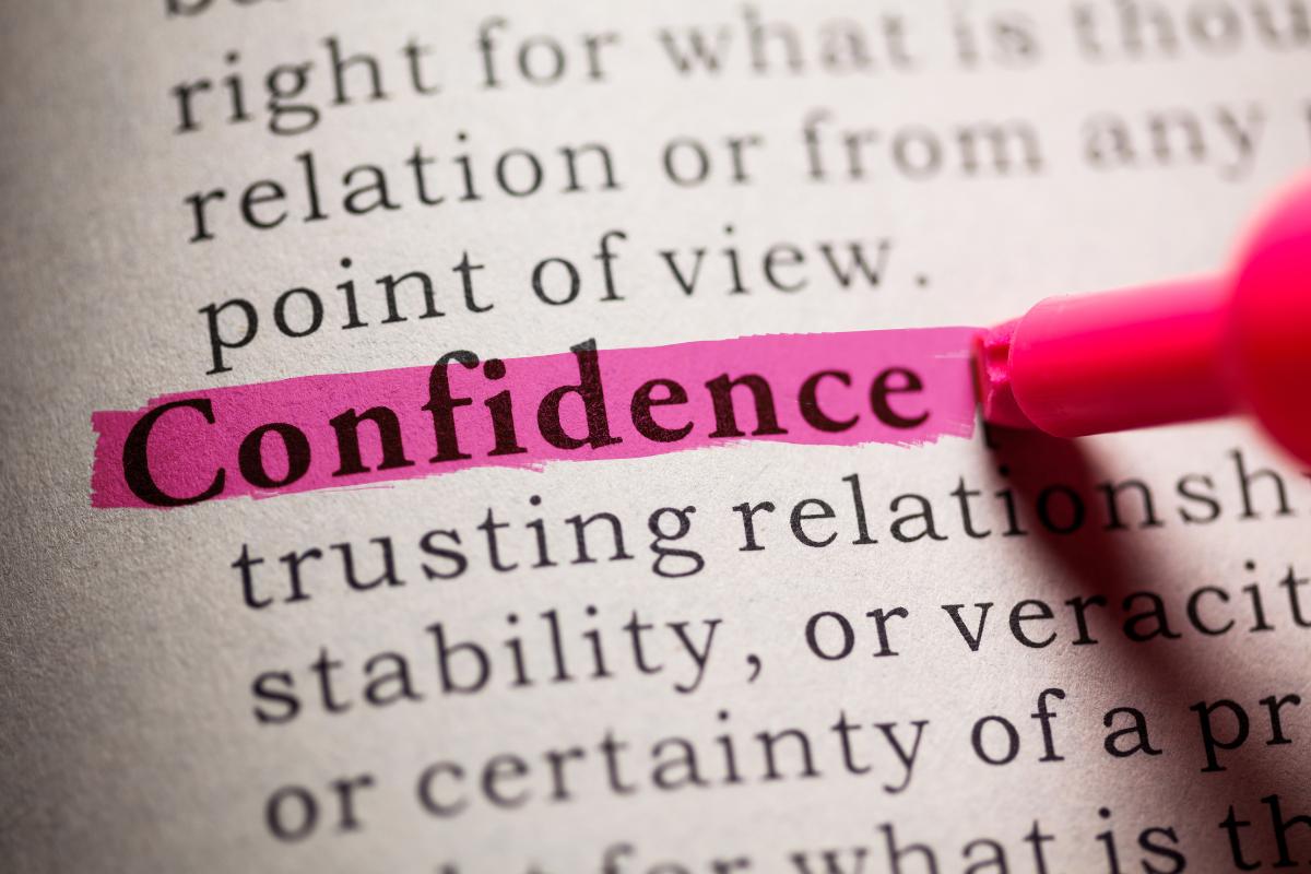 A pink highlighter marks the word "Confidence" in bold on a printed page, reminding you to build confidence and stop worrying what people think as you focus on what truly matters among all the other words.