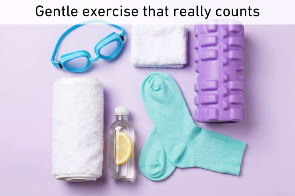 A pair of turquoise socks, a purple foam roller, swimming goggles, a small towel, and a bottle of water with lemon are arranged on a light purple background. Text above reads, “gentle exercise that really counts. ” this inviting scene celebrates the essentials for effective exercise in a soothing palette.